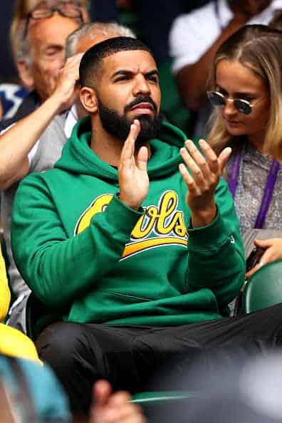 Drake applauds while attending Day Eight: The Championships - Wimbledon 2018 wearing green OWLS sweatshirt