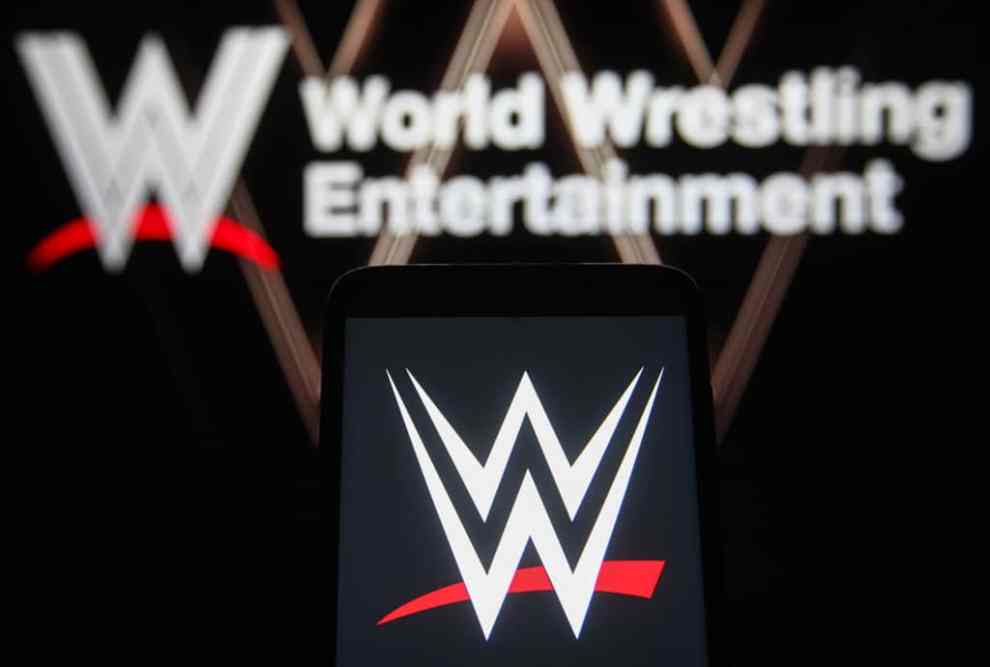 UKRAINE - 2021/08/25: In this photo illustration a World Wrestling Entertainment (WWE) logo is seen on a smartphone and a pc screen.