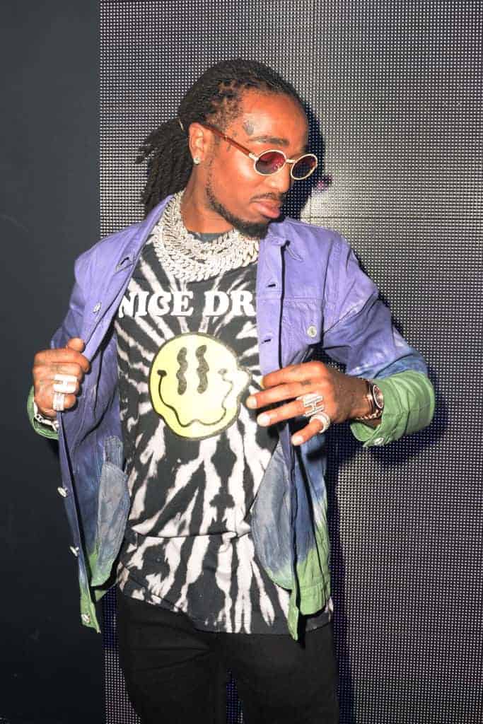 Quavo wearing purple and green jacket