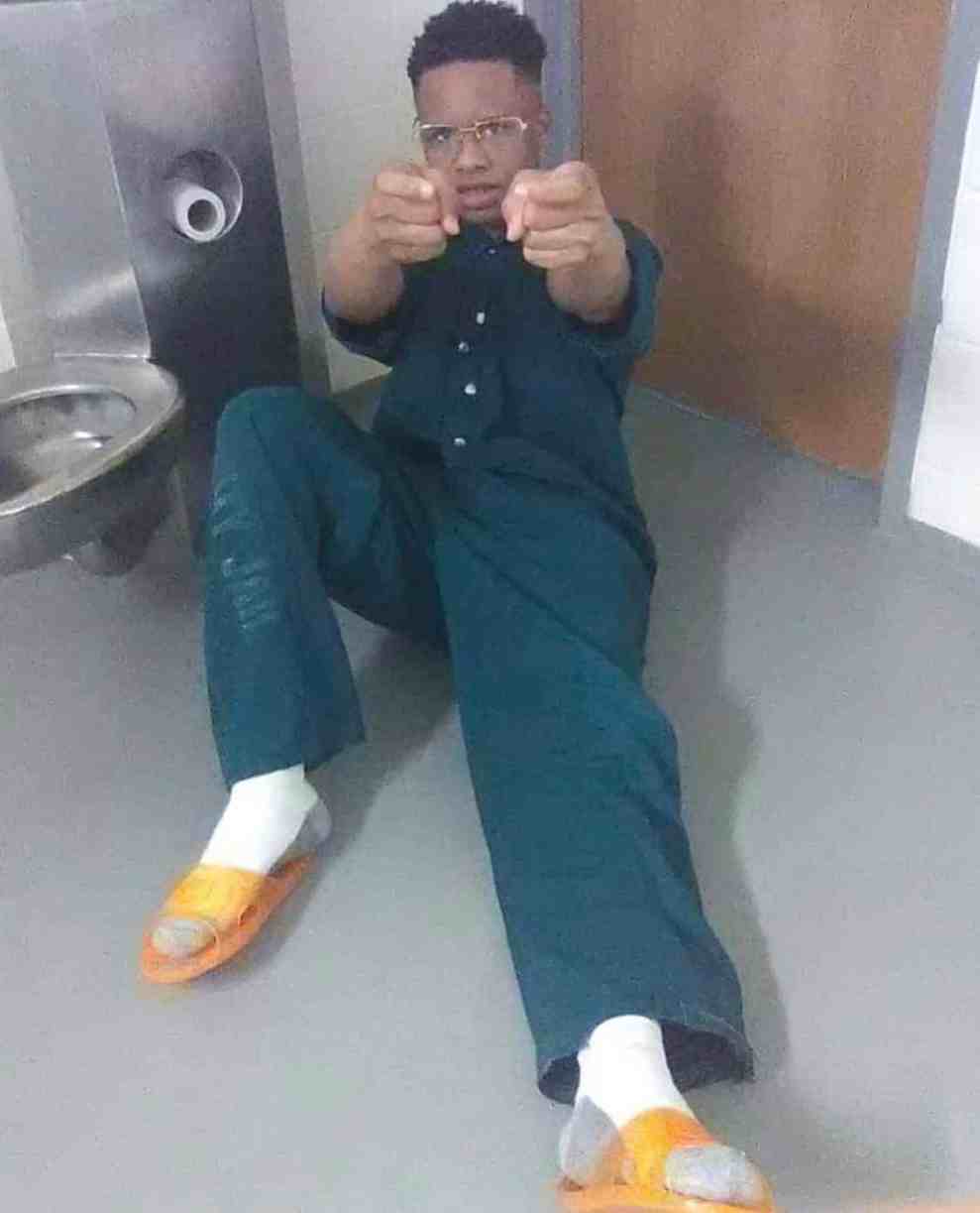 Tay-K wearing a green jumpsuit in jail
